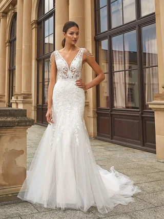 Braut in einem figurbetonten Mermaid-Kleid vor einer Fassade