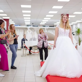 Braut auf dem roten Catwalk mit applaudierenden Begleitungen